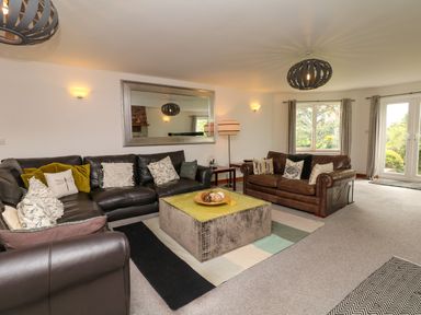 A living room with two leather sofas cushions a large mirror and a central coffee table at Nairn in Braunton