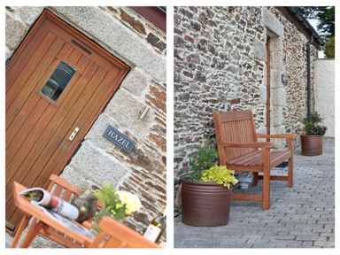 A wooden door with a sign reading Hazel on a stone wall and a wooden bench with potted plants outside a building at Hazel Barn in Falmouth