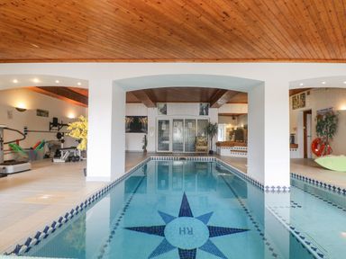 An indoor swimming pool with a blue star pattern on the floor and exercise equipment on the side at Bight Boathouse in Dartmouth