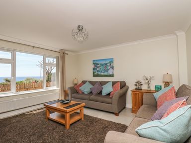 A living room with sofas and cushions a wooden coffee table and a side cabinet with lamps at Hagar Vor in Marazion