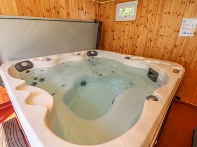 An indoor hot tub with water and wooden paneled walls at Hagar Vor in Marazion