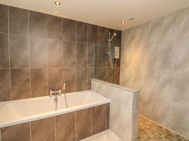A bathroom with a bathtub and a walk in shower at Lake View in Kingsand and Cawsand