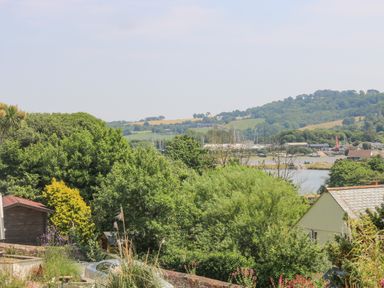 A view of a garden with dense trees overlooking a river and hills at Lake View in Kingsand and Cawsand