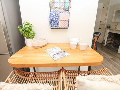 A kitchen table with a teapot two mugs a plant and a magazine at Cool Stone Cottage in Instow near Bideford