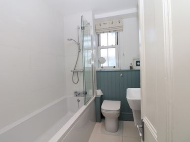 A bathroom with a bathtub shower combination toilet and sink at Cool Stone Cottage Instow near Bideford