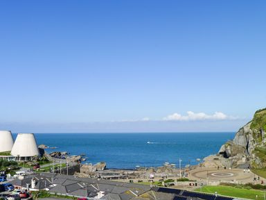A coastal view with buildings, rocky shore, and the sea at 5 Arlington Villas in Ilfracombe