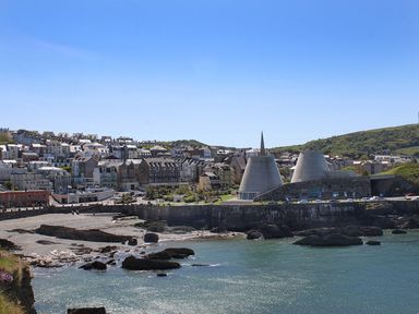 A coastal town with buildings hills and large concrete structures near the water at 5 Arlington Villas in Ilfracombe