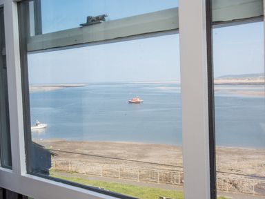 A window view overlooking a river with boats and a sandy shore at The Crab Shell in Appledore near Bideford
