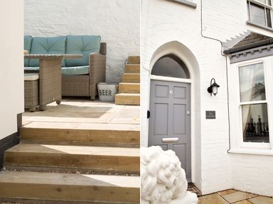 A patio with outdoor wicker furniture and steps next to the front entrance door numbered 6 at The Crab Shell Appledore near Bideford