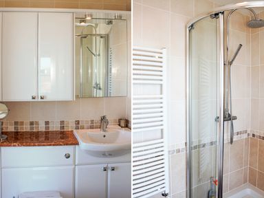 A bathroom with a sink and mirror cabinet next to a shower enclosure at Ocean Breeze in Ilfracombe