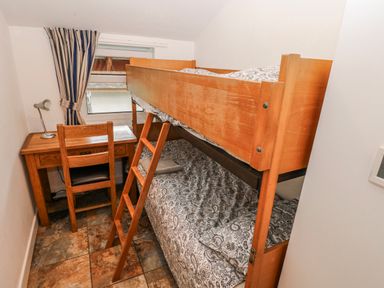 A bedroom with a bunk bed, desk, and chair at Trelessy Lodge Llanteg near Amroth