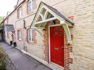 A stone exterior wall with a red door marked 93 and a small porch at Blenheim Edge The Causeway in Woodstock