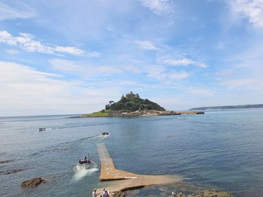 A coastal scene with boats on the water near an island with a castle at Star House in Marazion