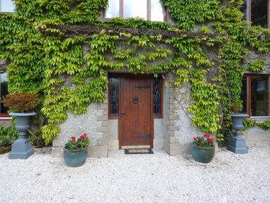 A wooden door with glass panels on a stone wall covered with ivy plants at Maifield in Carrick-On-Suir County Tipperary