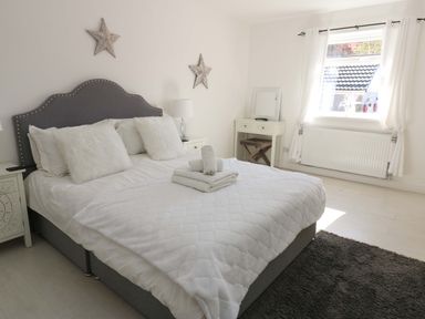 A bedroom with a bed and nightstand at Blacksmiths Cottage in Shilbottle