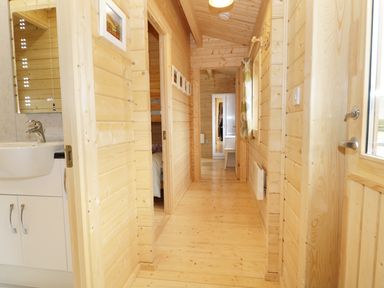 A wooden hallway with a sink on the left side and a door on the right at The Shippen in Merriott