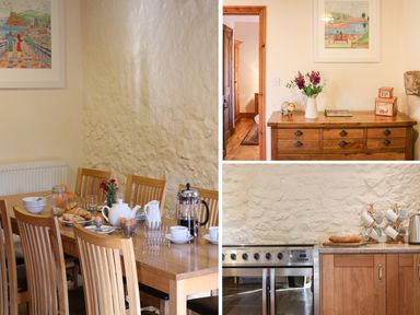 A dining table set with breakfast items and wooden chairs next to a stone wall at Carthorse Cottage in Teignmouth
