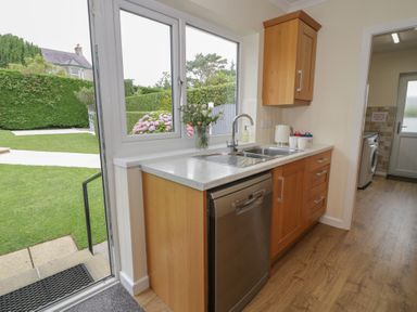 A kitchen with a sink and dishwasher at Bay View Benllech