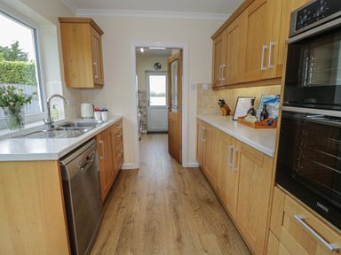 A kitchen with cabinets and appliances at Bay View in Benllech