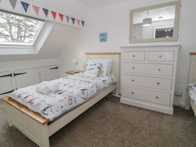 A bedroom with a bed and chest of drawers at Bay View in Benllech