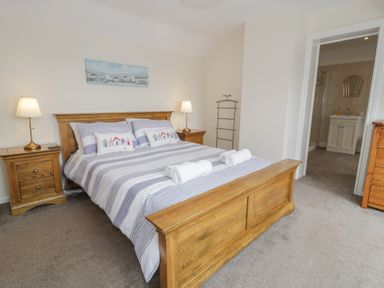A bedroom with a bed and side tables at Bay View in Benllech