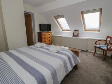 A bedroom with a bed and a TV at Bay View in Benllech