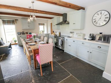 A kitchen with a dining table and chairs at Crane Field Laithe Otterburn, North Yorkshire