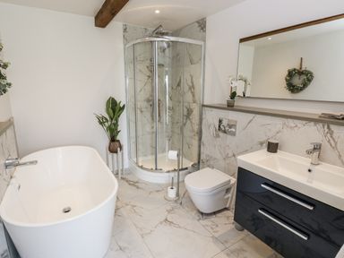 A bathroom with a bathtub and a shower at Crane Field Laithe Otterburn, North Yorkshire