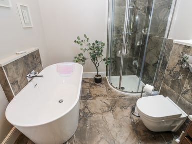 A bathroom with a bathtub and shower at Crane Field Laithe, Otterburn, North Yorkshire