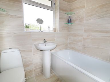 A bathroom with a toilet sink bathtub and window at Anneddle in Four Mile Bridge