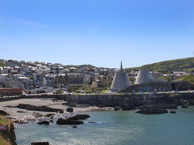 A coastal town with buildings near the shore and unique conical structures at No 6 Arlington Villas in Ilfracombe