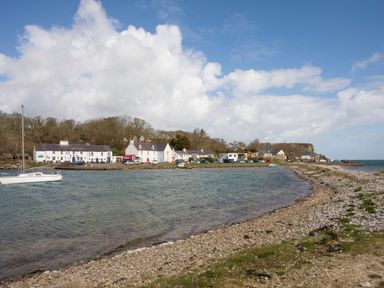 A coastal village with houses boats and a pebble beach at Glan Dwr in Red Wharf Bay