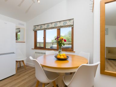 A dining room with a table and chairs at Costentyn, Tor Down Quarry St Breward