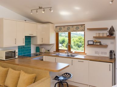 A kitchen with wooden countertop and window at Costentyn, Tor Down Quarry in St Breward