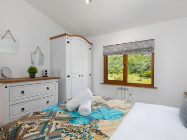 A bedroom with a bed and a wardrobe at Costentyn, Tor Down Quarry in St Breward