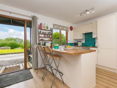 A kitchen with countertop and bar stools at Tressa, Tor Down Quarry in St Breward