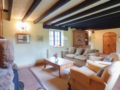 A living room with a sofa set wooden coffee table and wooden cabinet at Old Winery Cottage Golant near Fowey