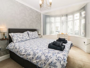 A bedroom with a double bed and two bedside lamps at Pier View in Paighton