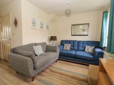 A living room with two sofas a lamp a mirror and framed pictures on the wall at 104 Sunrise Drive in Filey