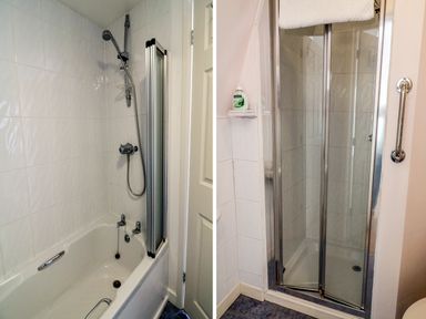 A bathroom with a bathtub and showerhead on the left and a closed glass shower enclosure on the right at 10 Oceanside in Ilfracombe