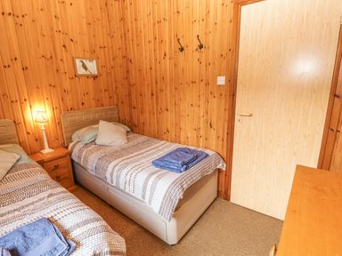 A bedroom with two single beds and a nightstand at 26 Dukes Meadow Greystoke near Penrith
