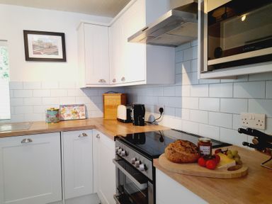 A kitchen with various appliances and food items at Crab Cottage in Ilfracombe