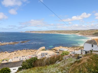 A coastal view with a beach rocky shore parking area and buildings at Sennen Heights in Sennen Cove near Penzance