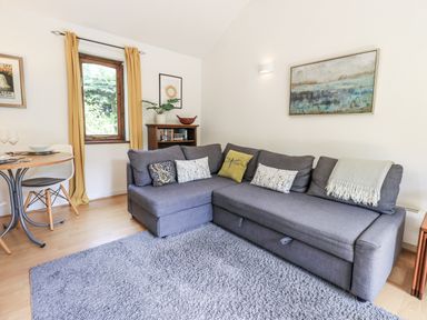 A living room with a sofa and dining table at Doe Foot Cottage in Ingleton