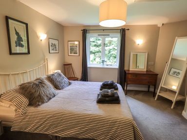 A bedroom with a bed and a table at Doe Foot Cottage Ingleton