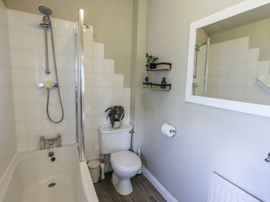 A bathroom with a shower, bathtub, toilet, and shelf at Doe Foot Cottage Ingleton