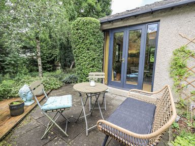 An outdoor seating area with a table and chairs at Doe Foot Cottage Ingleton