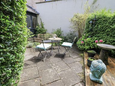 A garden with a table and chairs at Doe Foot Cottage Ingleton
