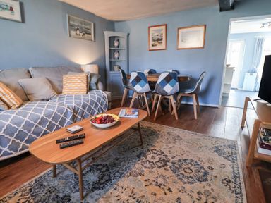 A living room with a coffee table and sofa at Delphinium Blakeney, Norfolk