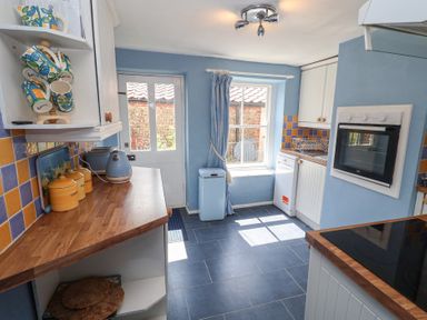 A kitchen with a kettle and mugs on a shelf at Delphinium Blakeney, Norfolk